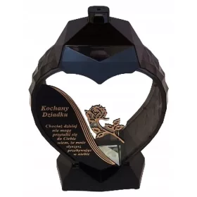    Una grande candela nera e oro a forma di cuore con un fiore di giglio per il nonno